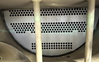 Inside view of an industrial evaporator tank, the ends of the water tubes are visible from the outside of the plate that holds the coolant inside the system