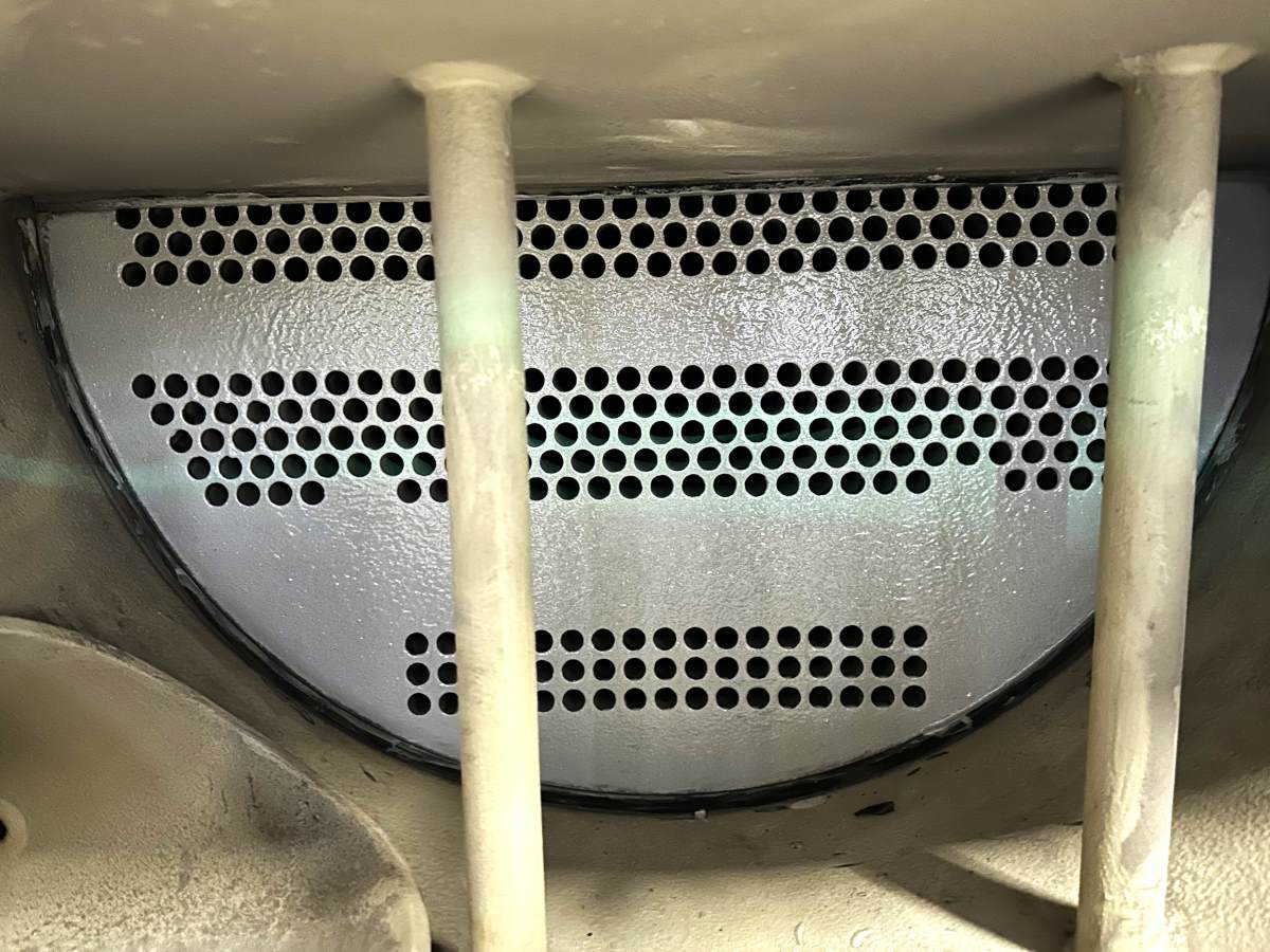 Inside view of an industrial evaporator tank, the ends of the water tubes are visible from the outside of the plate that holds the coolant inside the system